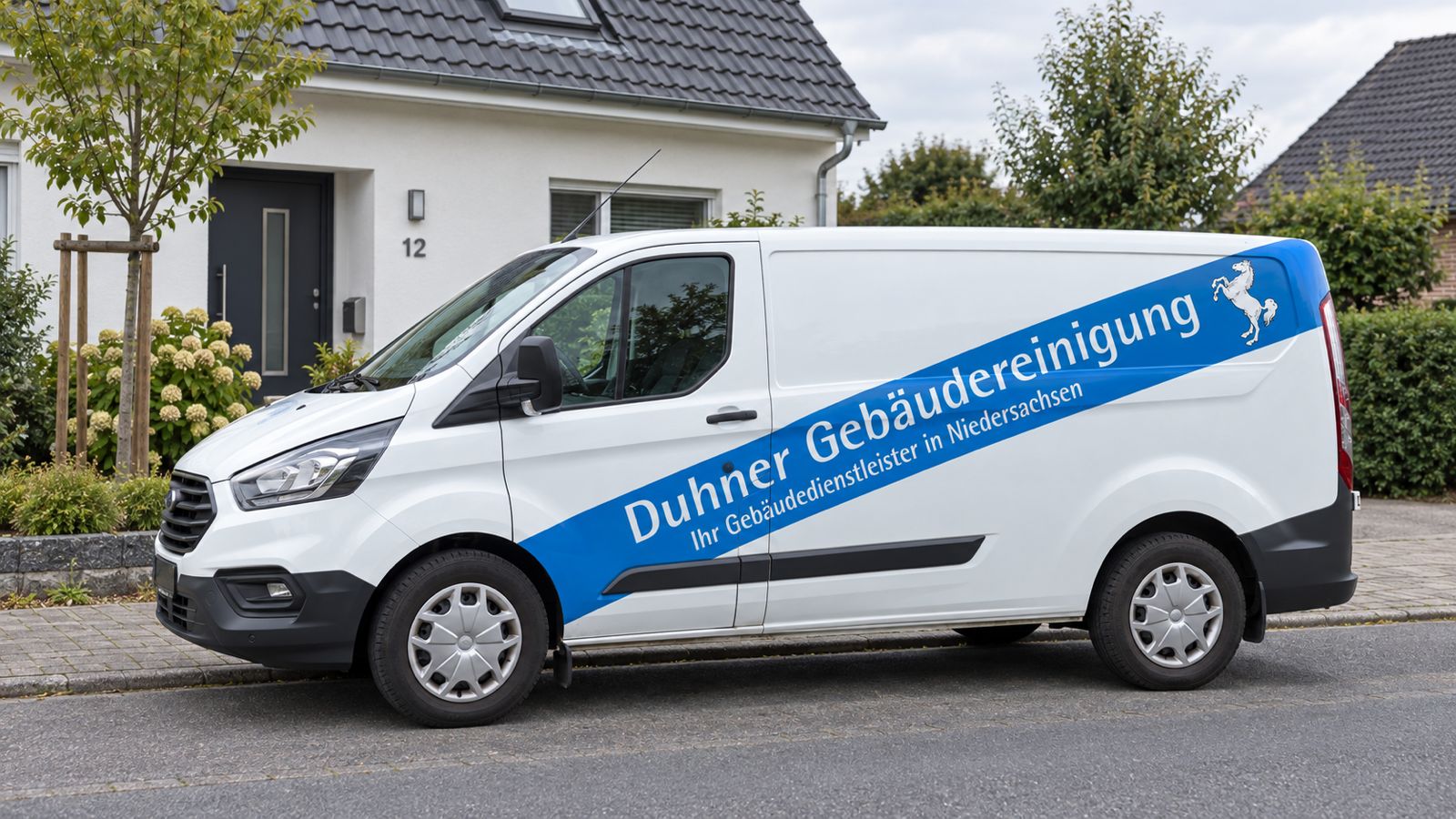 Duhner-Einsatzfahrzeug mit blau-weißer Firmenbeschriftung vor einem Einfamilienhaus